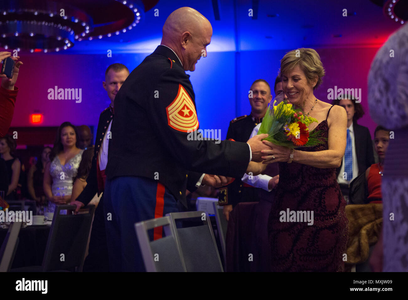 Denise Glynn, wife of U.S. Marine Corps Brig. Gen. James F. Glynn, director, Office of United State Marine Corps Communication, receives flowers from Sgt. Maj. Robert W. Pullen, battalion sergeant major, Headquarters & Service Battalion, Headquarters Marine Corps, during the Headquarters & Service Battalion Marine Corps Ball at the Renaissance Arlington Capitol View Hotel, Arlington, Va., Nov. 05, 2016. The ball was held in celebration of the Marine Corps’ 241st birthday. (U.S. Marine Corps photo by Pfc. Alex A. Quiles) Stock Photo