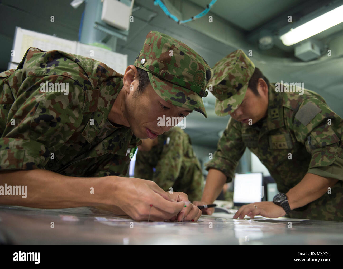 161108-N-ZK021-012 PACIFIC OCEAN (Nov. 8, 2016) - Sergeant First Class Tomoyuki Kjawano updates the plot board in the Flag Information Center (FIC) during Keen Sword 2017. Keen Sword 17 is a joint and bilateral field training exercise (FTX) between U.S. and Japanese forces meant to increase readiness and interoperability within the framework of the U.S. – Japan alliance. (U.S. Navy photo by Petty Officer First Class Nardel Gervacio/Released) Stock Photo