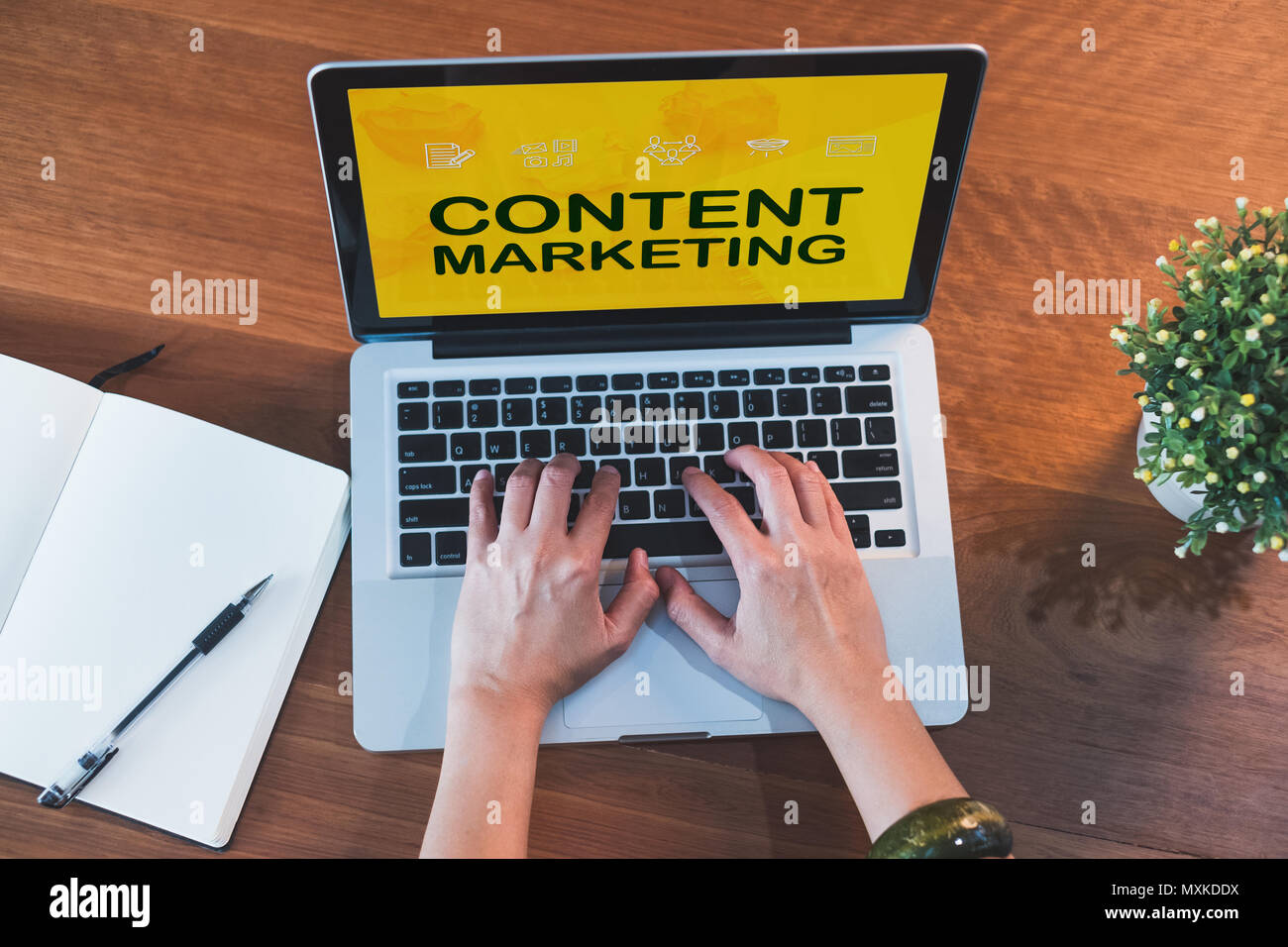 Top view hand type on laptop keyboard with content marketing on laptop  screen and plant on table at home.digital technology business.influencer and b Stock Photo