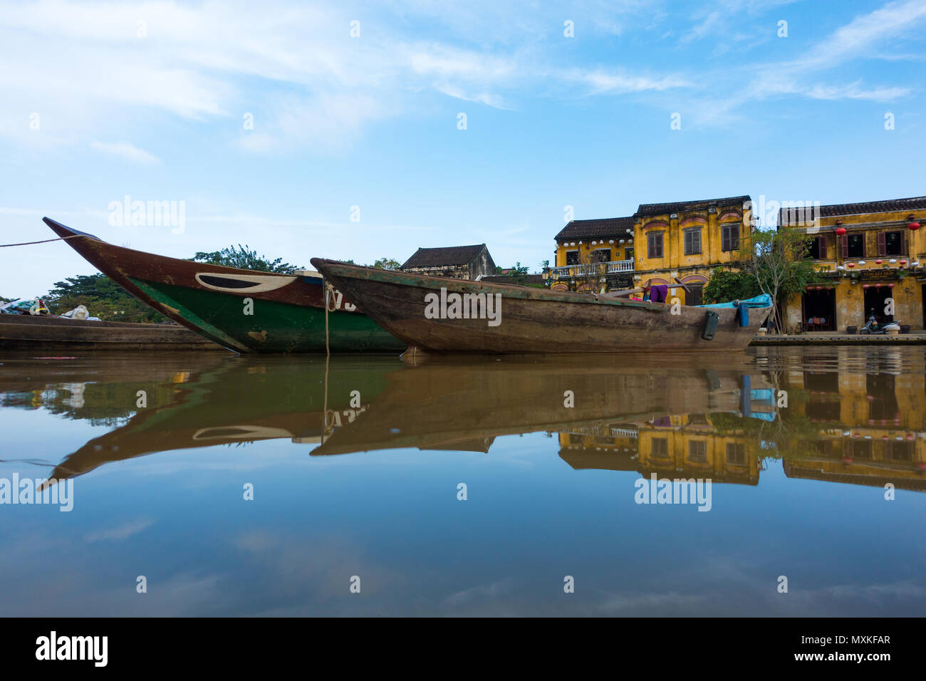 A sunny day at Hoai river with wooden boat anchored in Hoi An old town ...