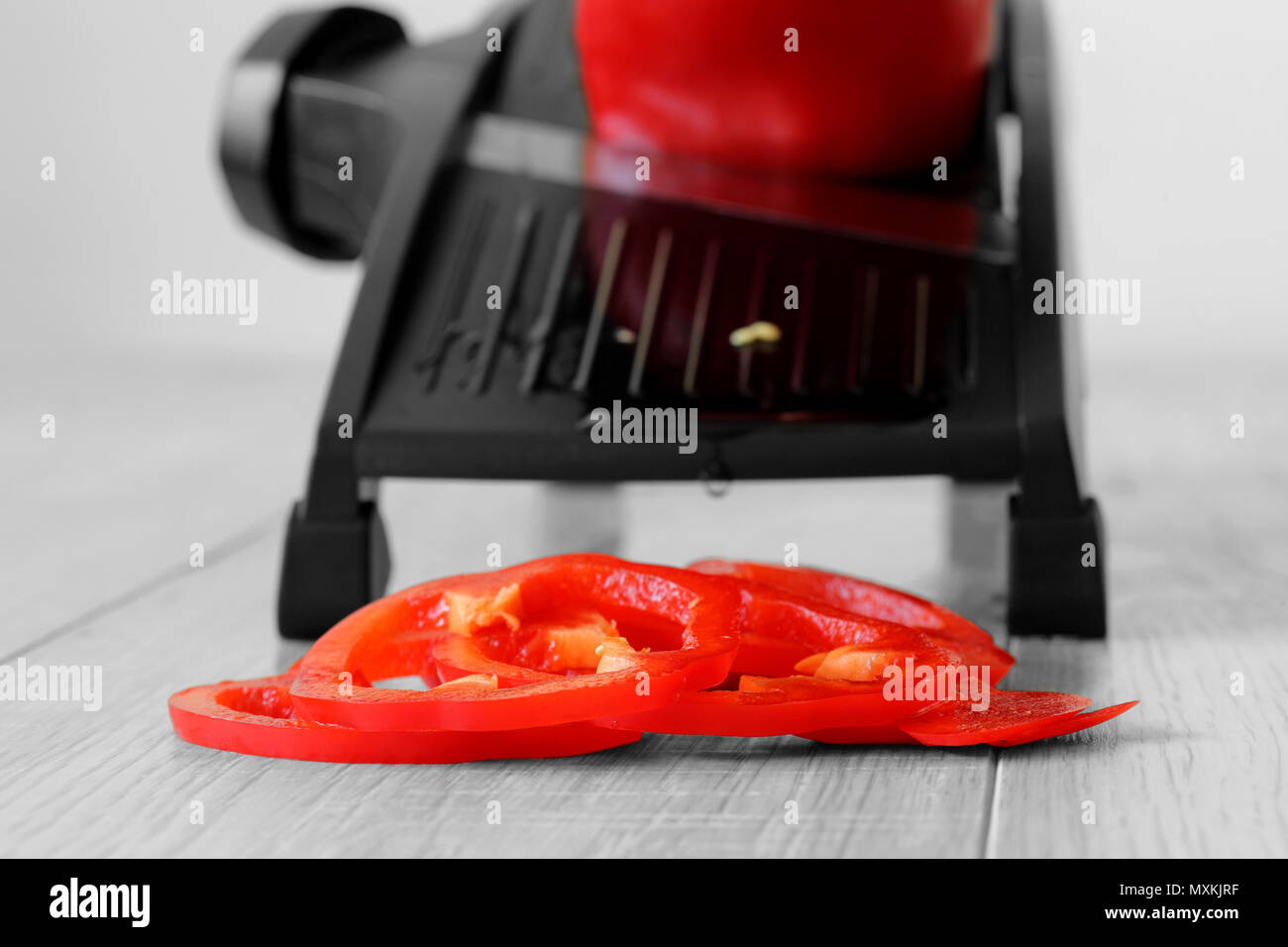 Red pepper sliced with mandoline on a grey wood kitchen worktop with selective colour Stock