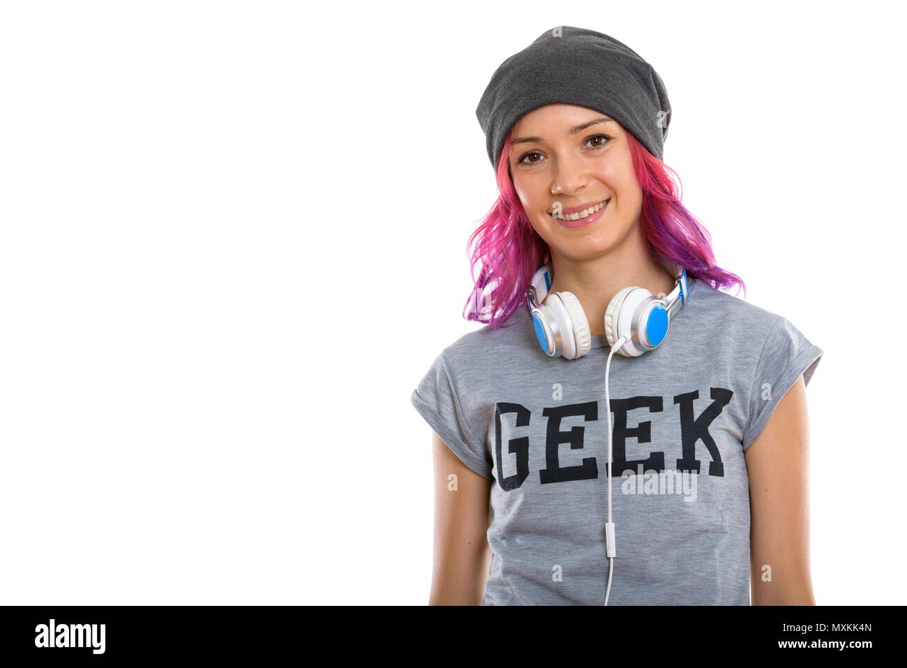 Studio shot of happy geek girl smiling with headphones around ne Stock Photo