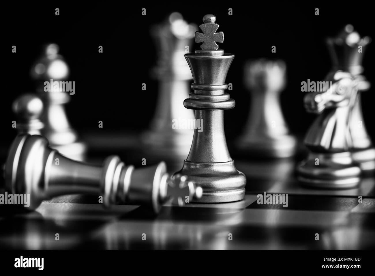 The King in battle chess game stand on chessboard with black isolated background. Business leader concept for market target strategy. Intelligence cha Stock Photo