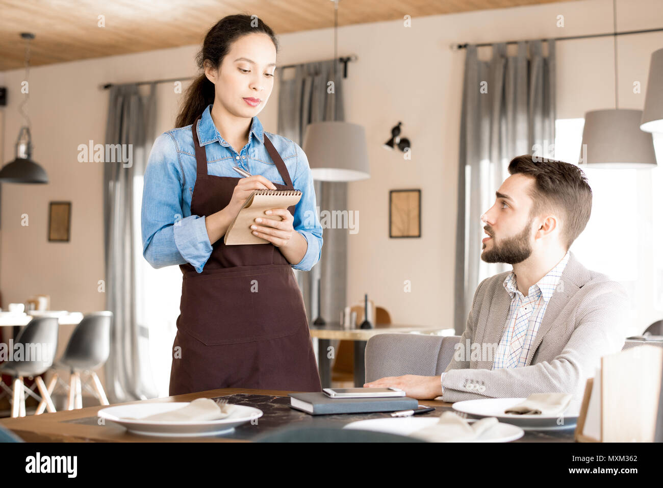 Serious waitress talking business lunch order Stock Photo Alamy