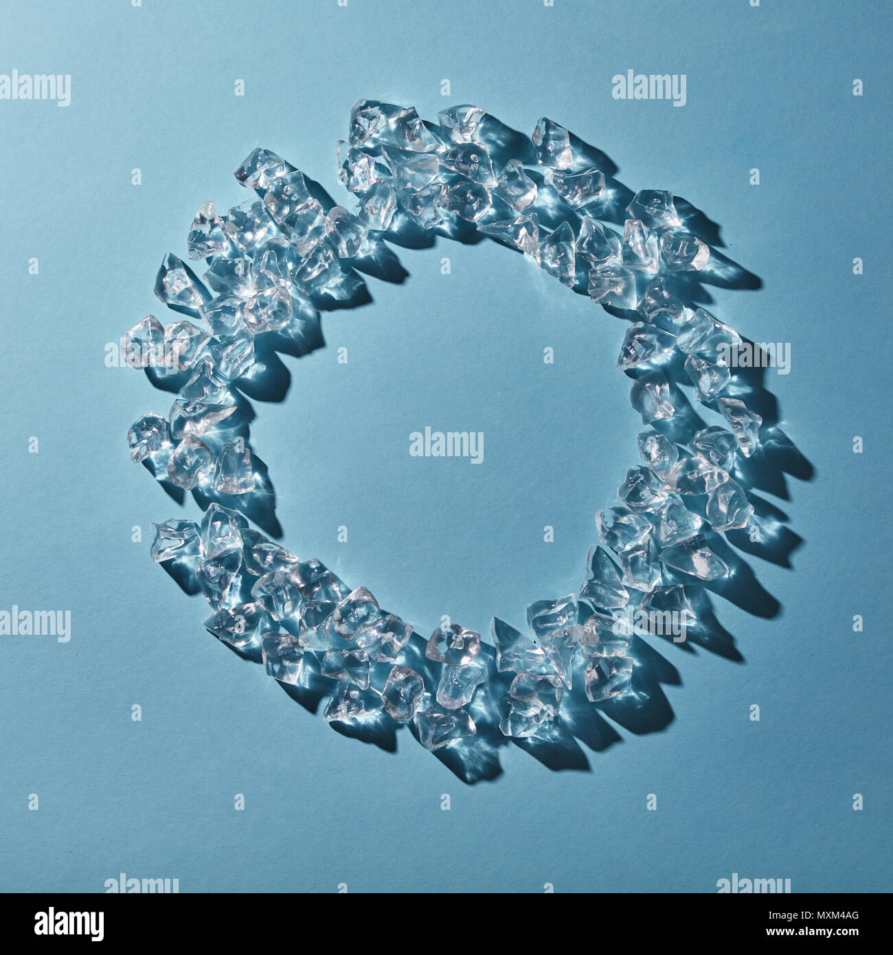 Cubes of cold ice in the form of a round frame on a blue background ...