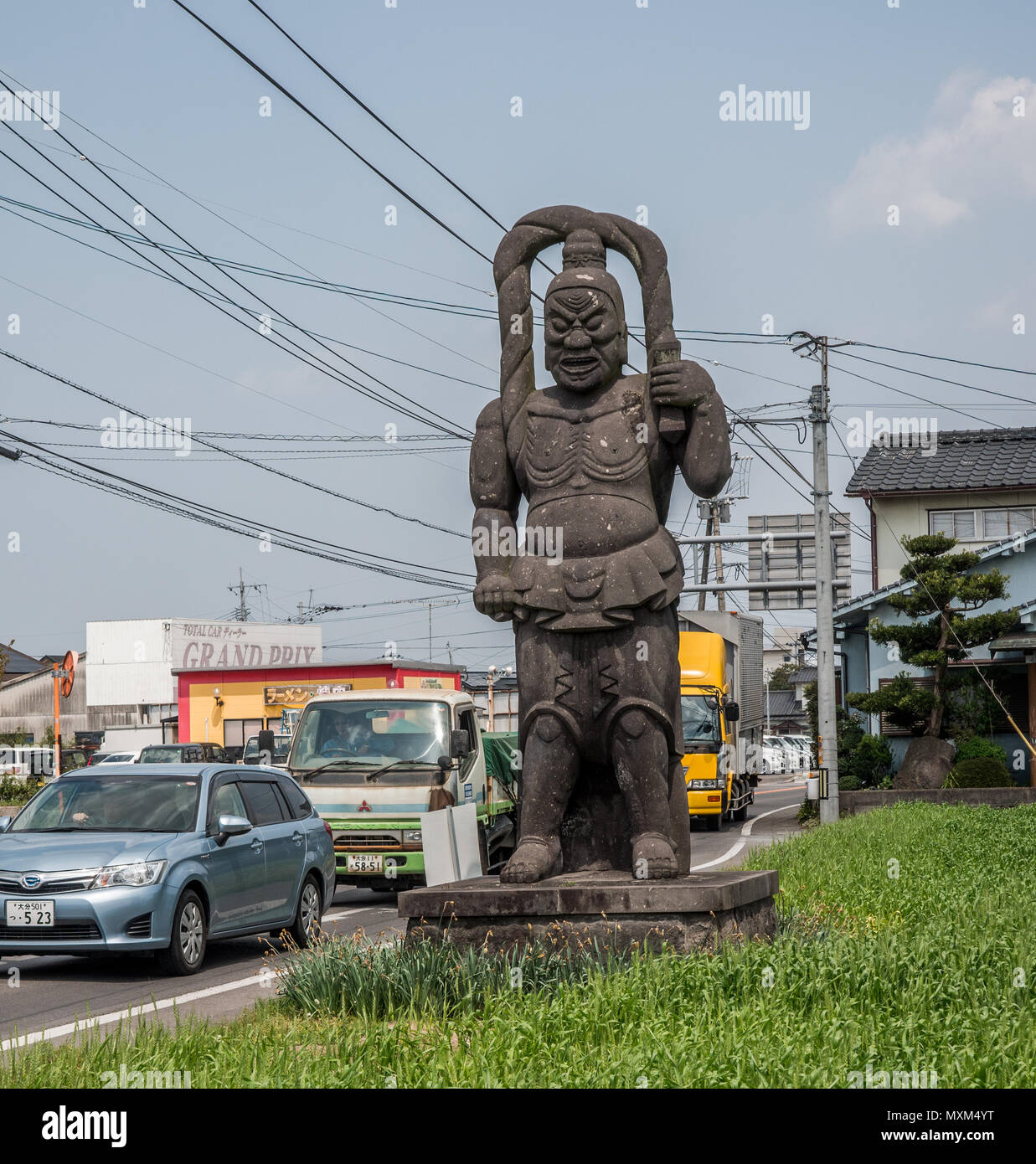 Nio temple guardian stone statue by busy main road, Kunisaki, Oita, Japan Stock Photo