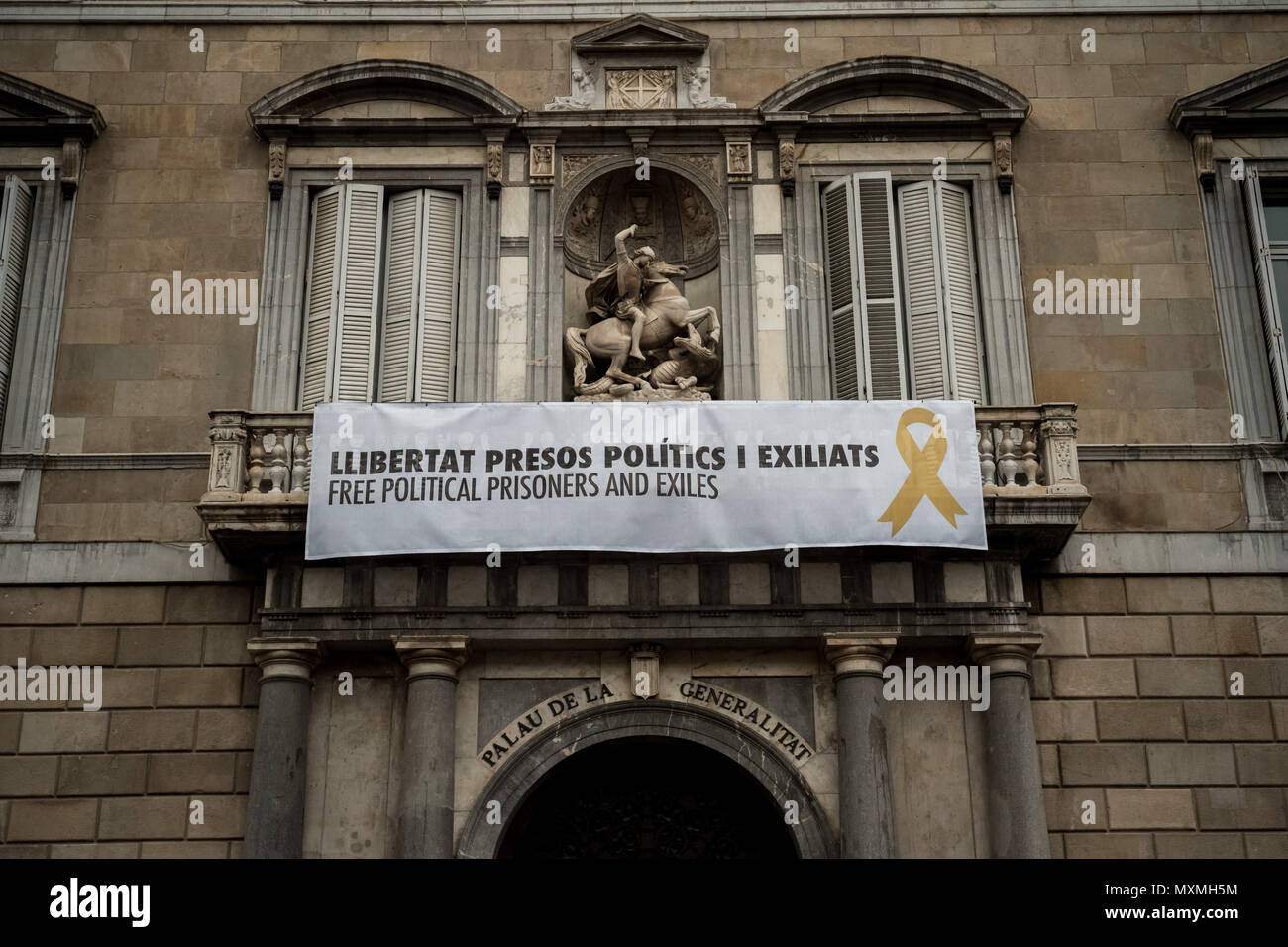 A banner reading 'Free political prisoners and exiles' hangs from the balcony of the Generalitat de Catalunya  in Barcelona. Stock Photo