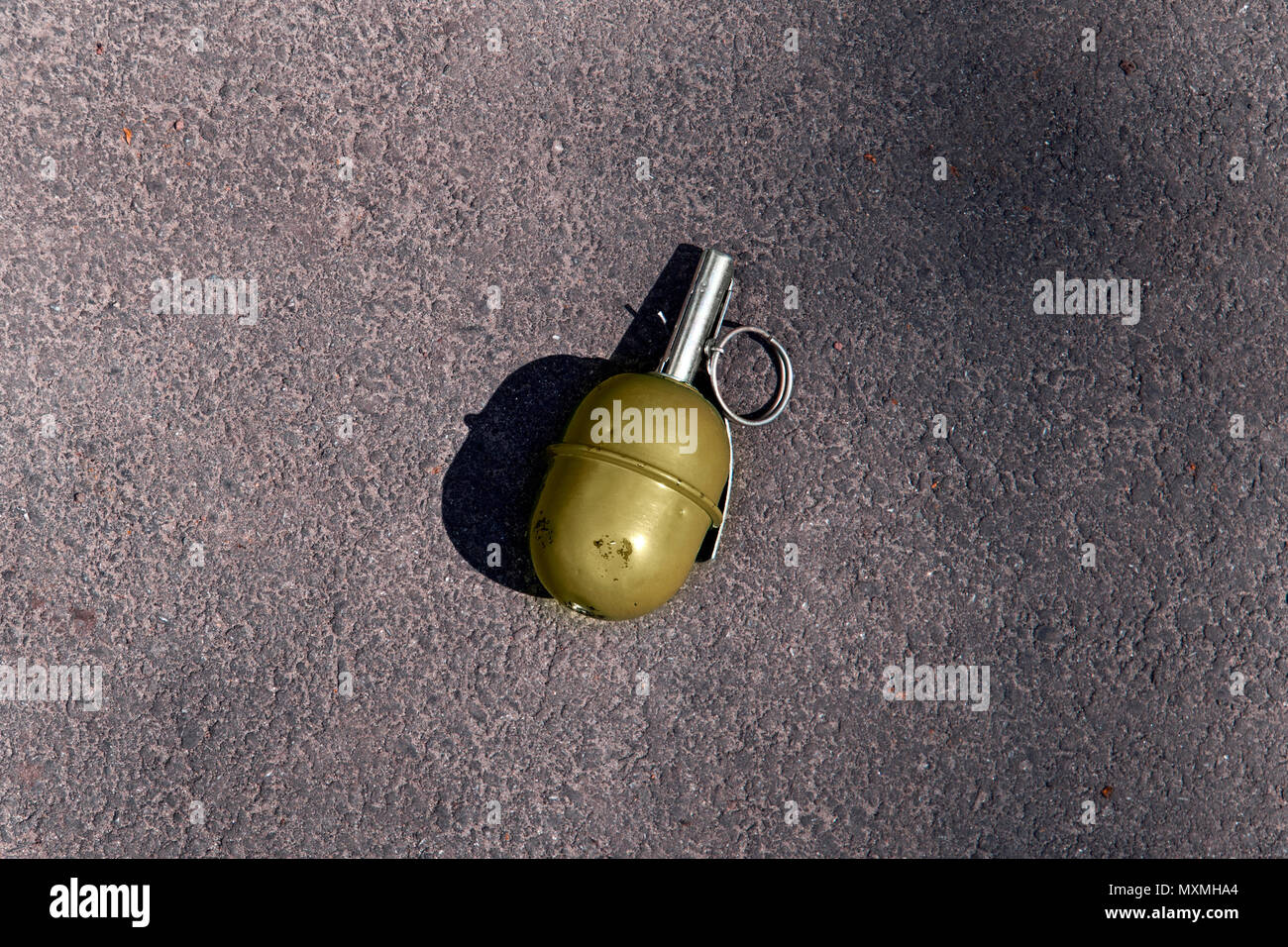 green grenade resting on a battlefield. Hand grenade RGD5 on asphalt