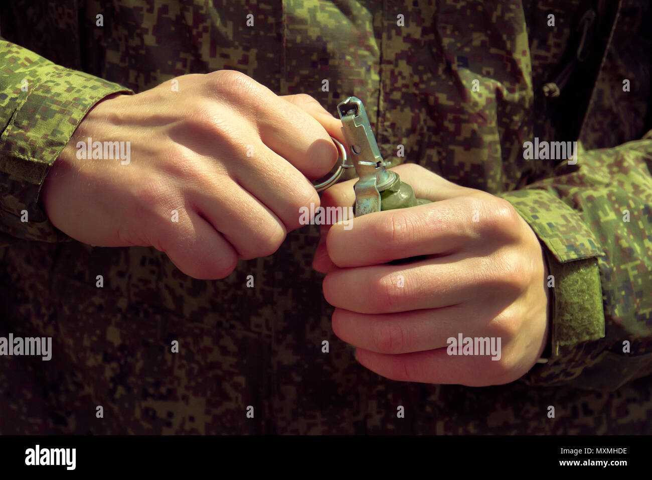Grenade, Hands on Pin. the soldier pulls a check from a fragmentation grenade RGD-5. Self-explosion. Stock Photo