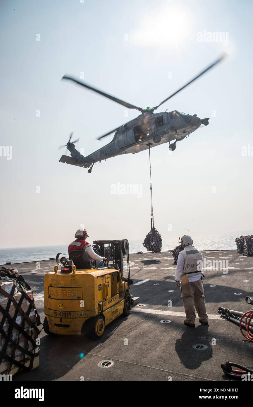 161119-N-RX777-199  ARABIAN GULF (Nov. 19, 2016) Civil service mariners aboard the fast combat support ship USNS Arctic (T-AOE 8) receive pallets from an MH-60S Sea Hawk helicopter assigned to the Dusty Dogs of Helicopter Sea Combat Squadron (HSC) 7 during a vertical replenishment with the dry cargo and ammunition ship USNS Alan Shepard (T-AKE 3). Arctic is deployed supporting coalition maritime forces ships in the U.S. 5th Fleet area of operations. (U.S. Navy photo by Petty Officer 3rd Class Cole Keller) Stock Photo