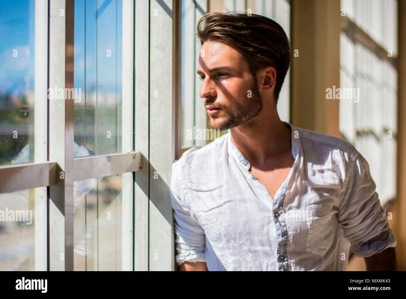 Serious young man standing inside modern building Stock Photo