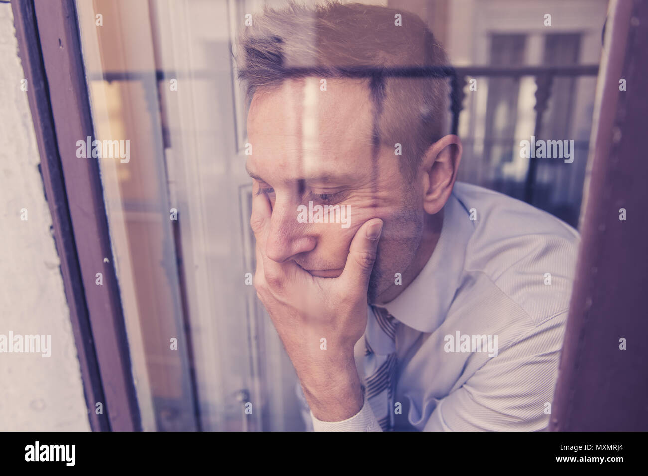 Close up portrait of middle aged man sad and depressed looking through ...