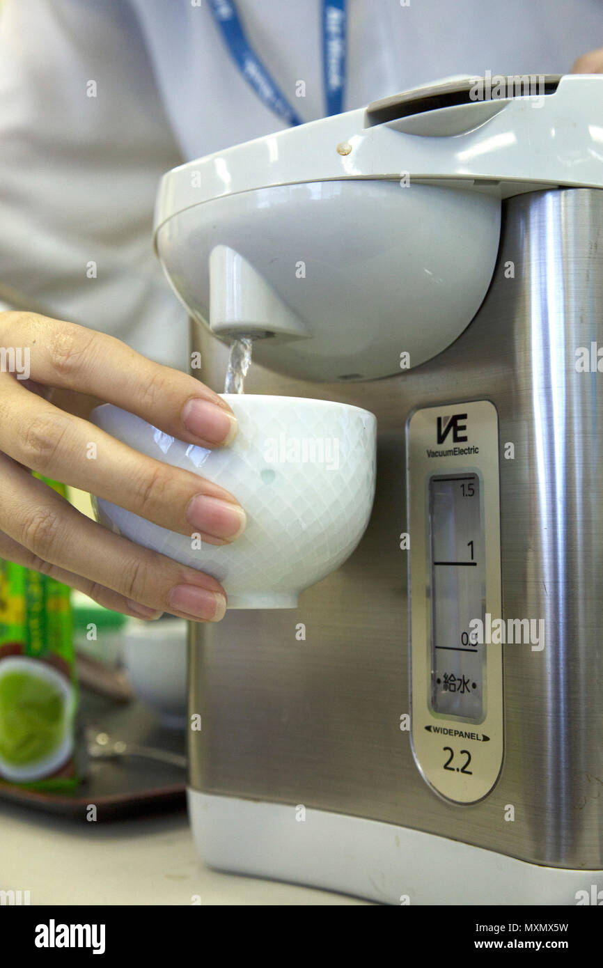 Tsuchiya Naoka demonstrates the proper tea steeping technique during a green tea seminar Nov. 22 on Camp Foster, Okinawa, Japan. Marine Corps Community Services hosted the class to teach Status of Forces Agreement members the historical background, health benefits and proper preparation of Japanese green tea, which is also called matcha. Naoka, a certified tea specialist who led the class, carefully demonstrated importance of paying close attention to the temperature of the water used to steep the tea leaves. According to Naoka, the temperature of the water used determines the health benefits  Stock Photo