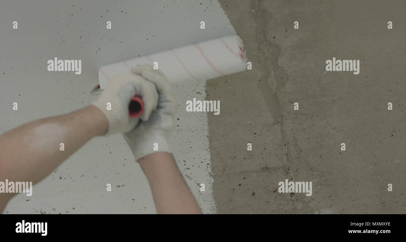 Painting Concrete Ceiling Into White With Roller Stock Photo