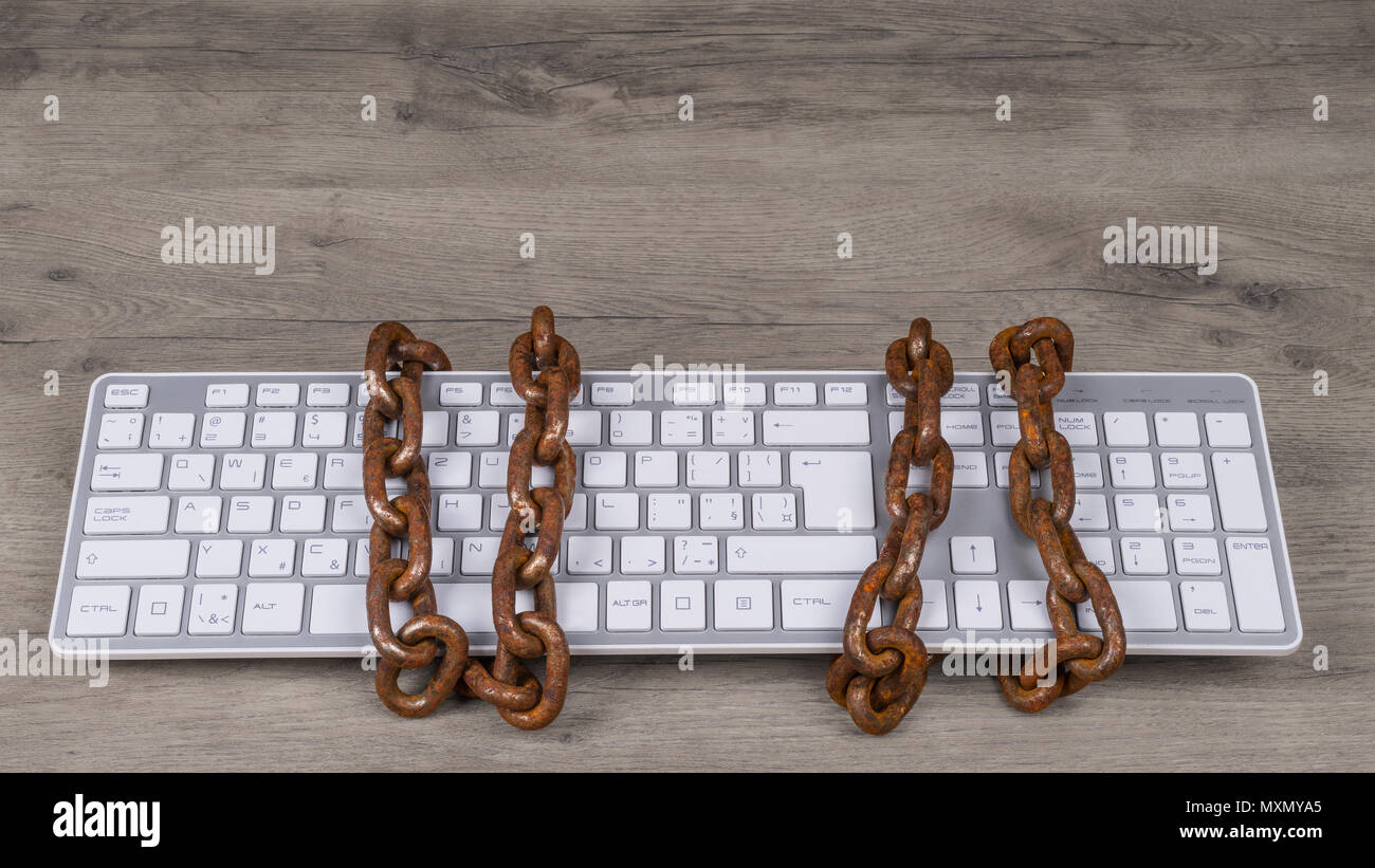 Computer keyboard tied with rusty chain. Old vintage chains on input device for digital informations. Concept of censorship, spy, cyber security, GDPR. Stock Photo