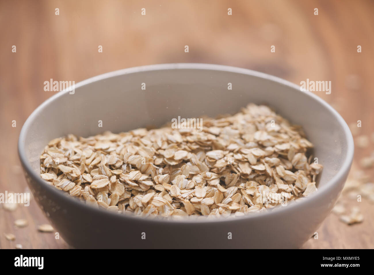 closeup oat flakes in white bowl with shallow focus Stock Photo