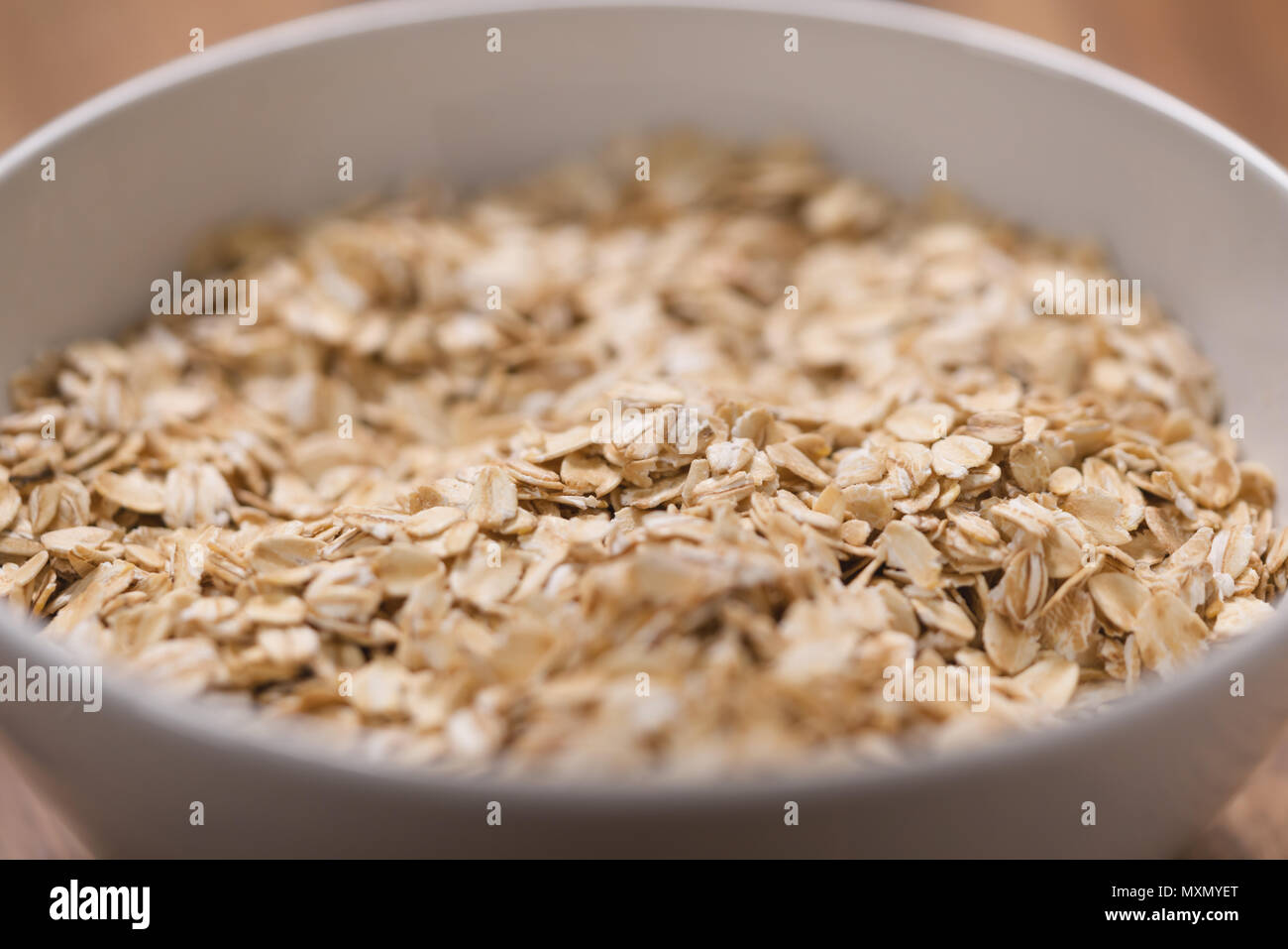 closeup oat flakes in white bowl with shallow focus Stock Photo