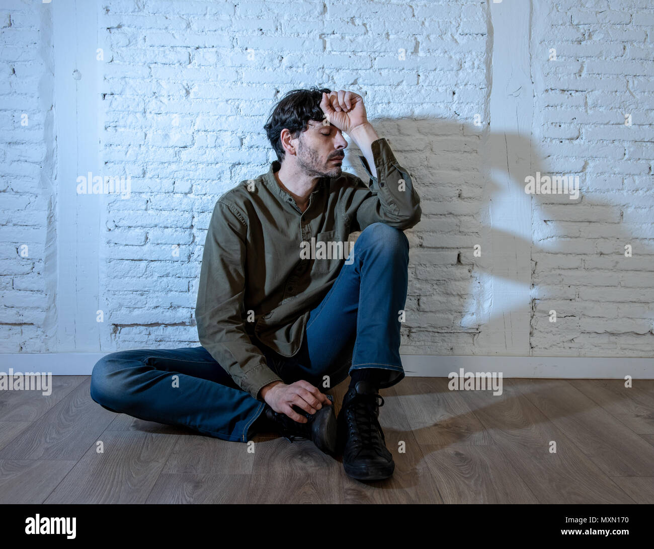 Young Depressed Man Sitting Against A White Wall At Home With A Shadow On The Wall Feeling Miserable Lonely And Sad In Mental Health Depression Conce Stock Photo Alamy