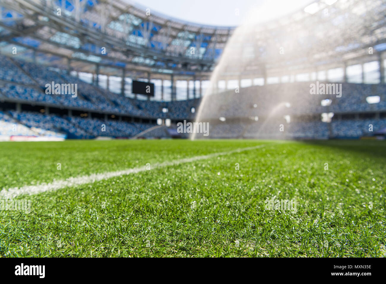 Watering the football field. Close-up macro shot on green grass with white stripe. Stock Photo