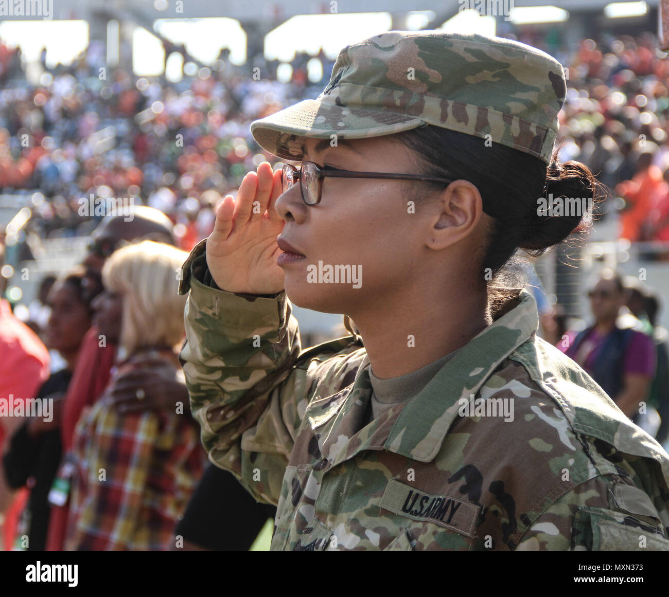 Army Staff Sgt. Sasha K. Adams, a female engagement team member for the Miami Recruiting Battalion, renders a salute as the national anthem plays inside Camping World Stadium in Orlando, Fla. Adams, a native of Ft. Worth, Texas, was one of several Soldiers from active duty and Reserve units received exclusive access to the field during the Florida Classic, one of the nation’s largest football rivalries between two historically black colleges: Bethune Cookman University and Florida A&M University. The troops engaged with thousands of fans through various interactive pre-game activities that enc Stock Photo