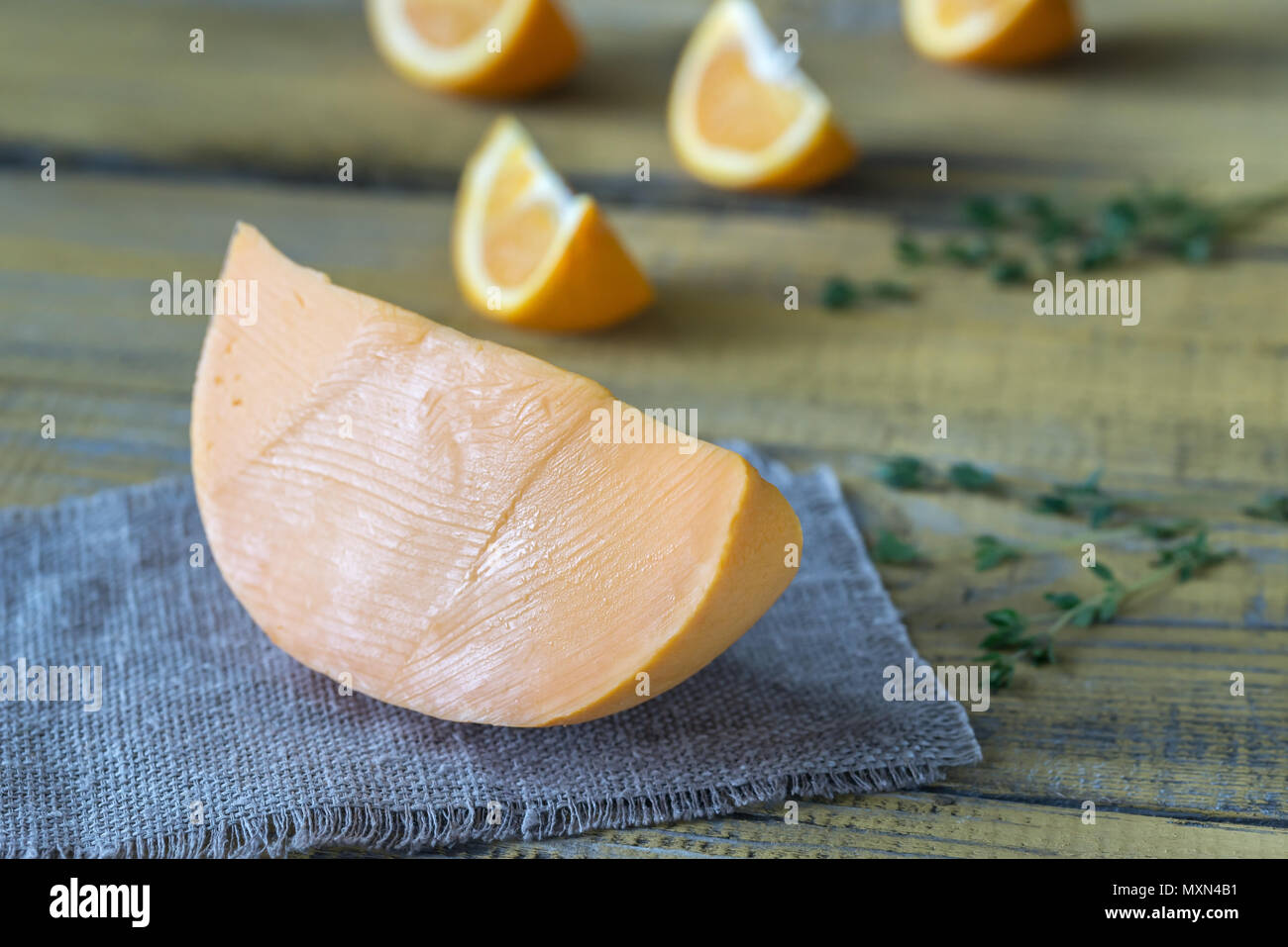 Mimolette cheese on the wooden board Stock Photo