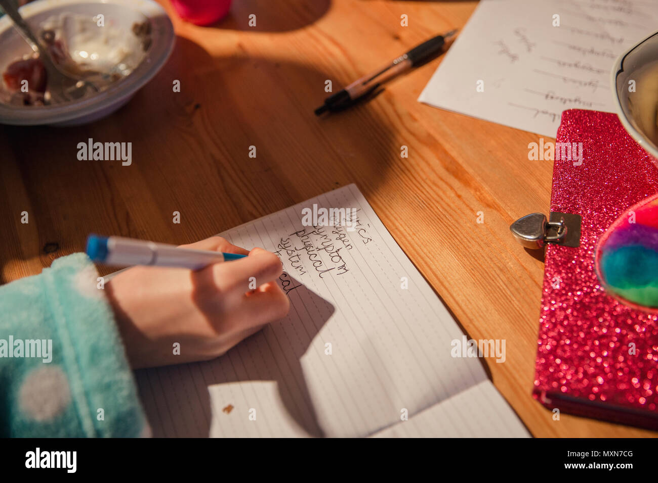 Close-up of a little girls hand writing her spellings out. Doing homework before school. Stock Photo