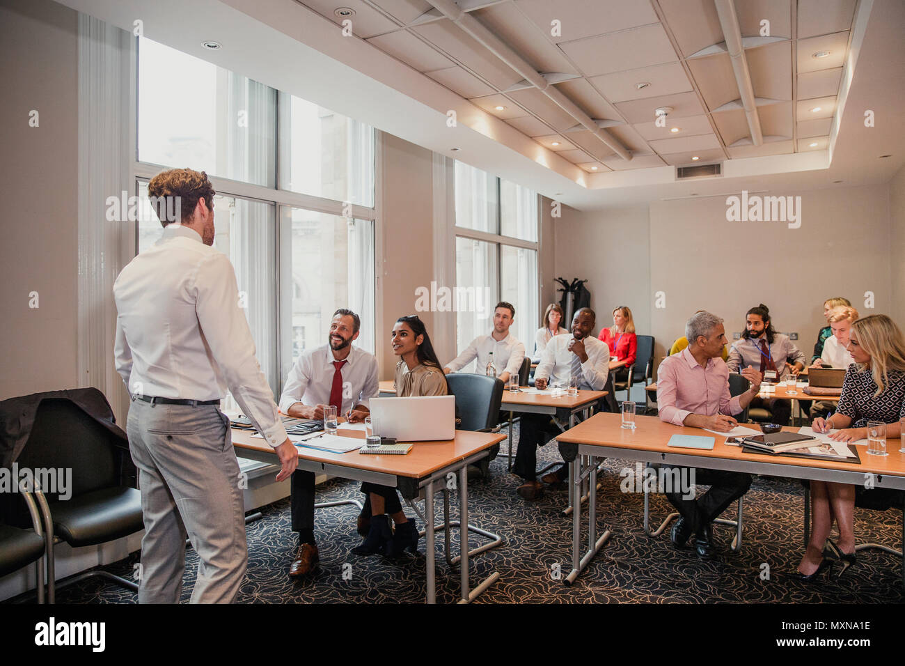 Rear view of an unrecognisable businessman giving a presentation at a conference. Stock Photo