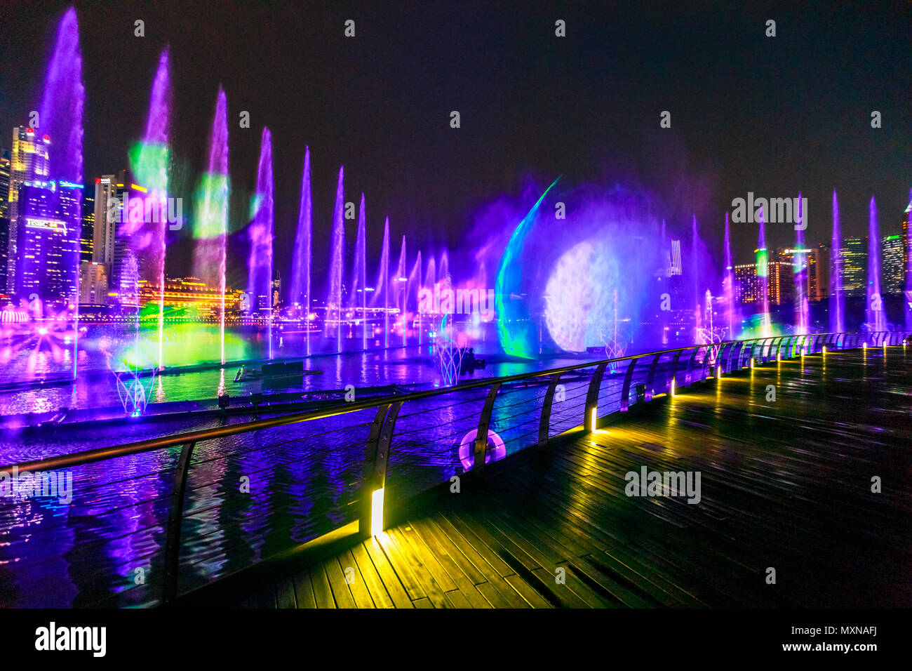 Singapore - April 26, 2018: Spectra: Light and Water Show at Event Plaza  along promenade in front of Marina Bay Sands. The show of dancing fountains  is one of biggest attractions in