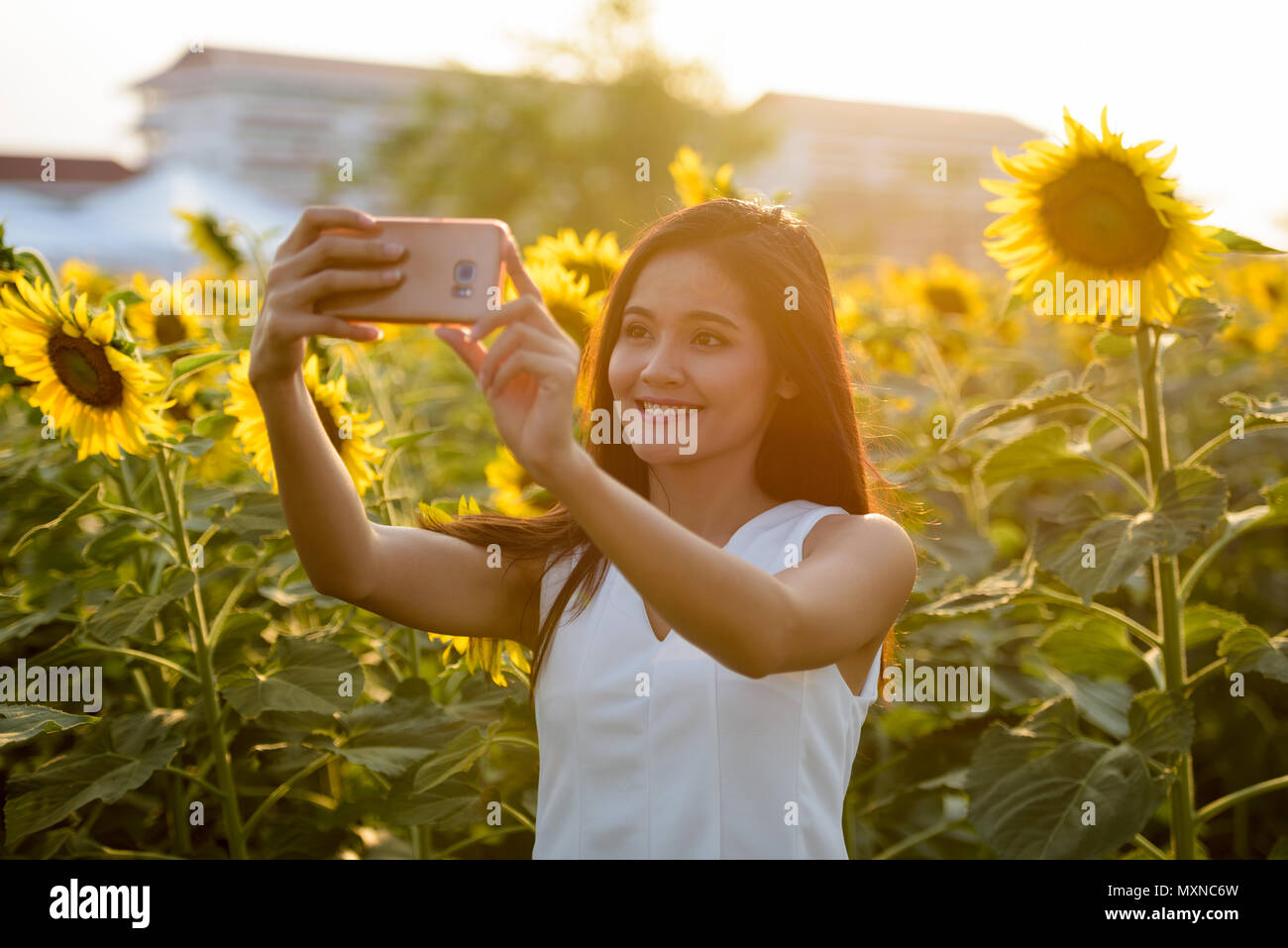 Young happy Asian woman smiling while taking selfie picture with Stock ...