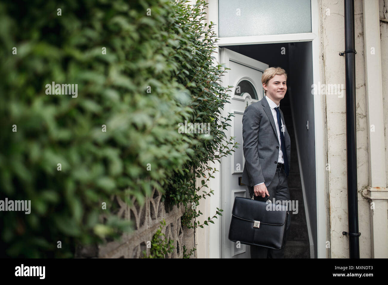 Young businessman leaving the house to commute to work. Stock Photo