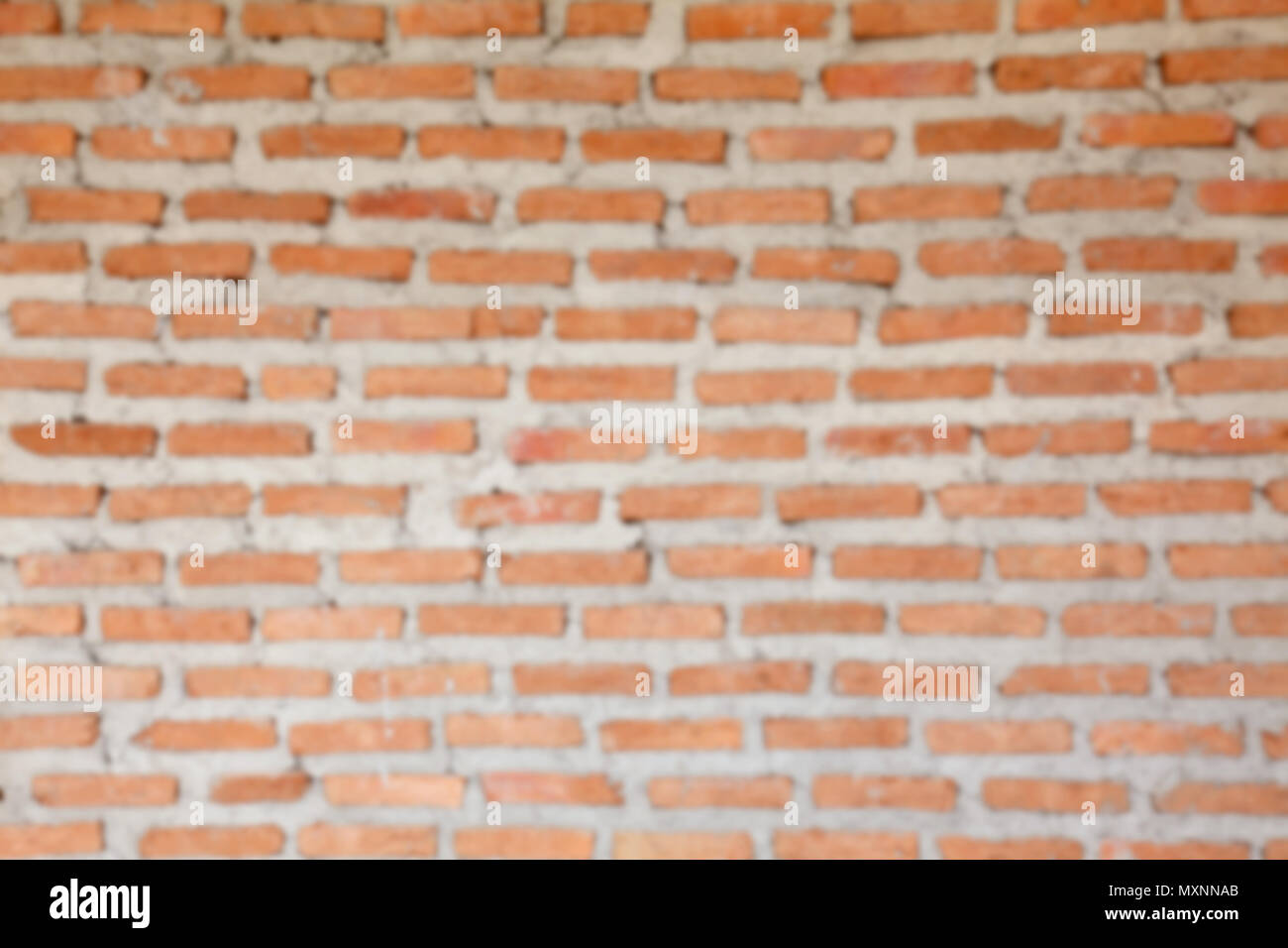 blur image of orange concrete block wall background and texture Stock Photo