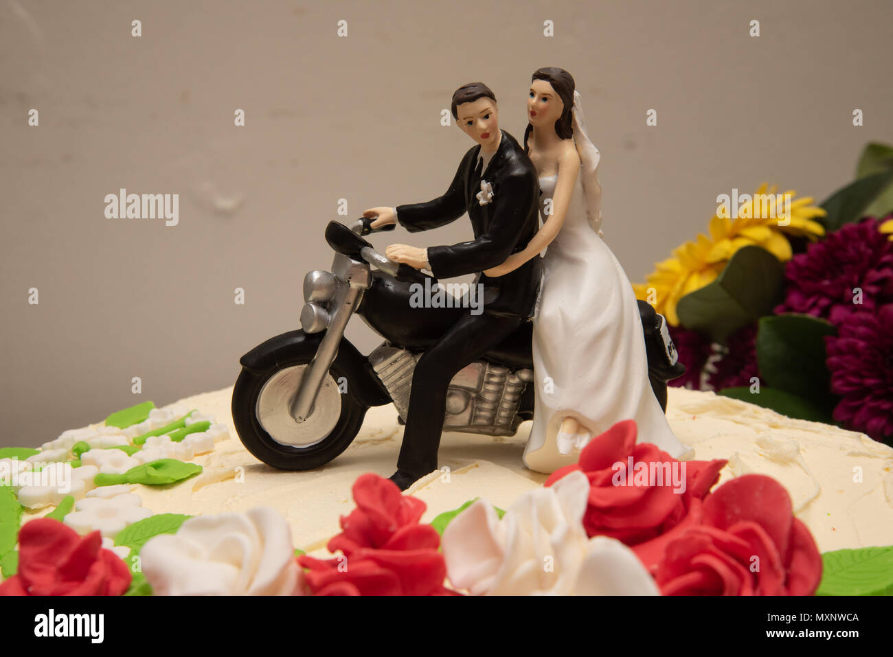 Cake topper: Bride and groom sitting on a motorcycle Stock Photo