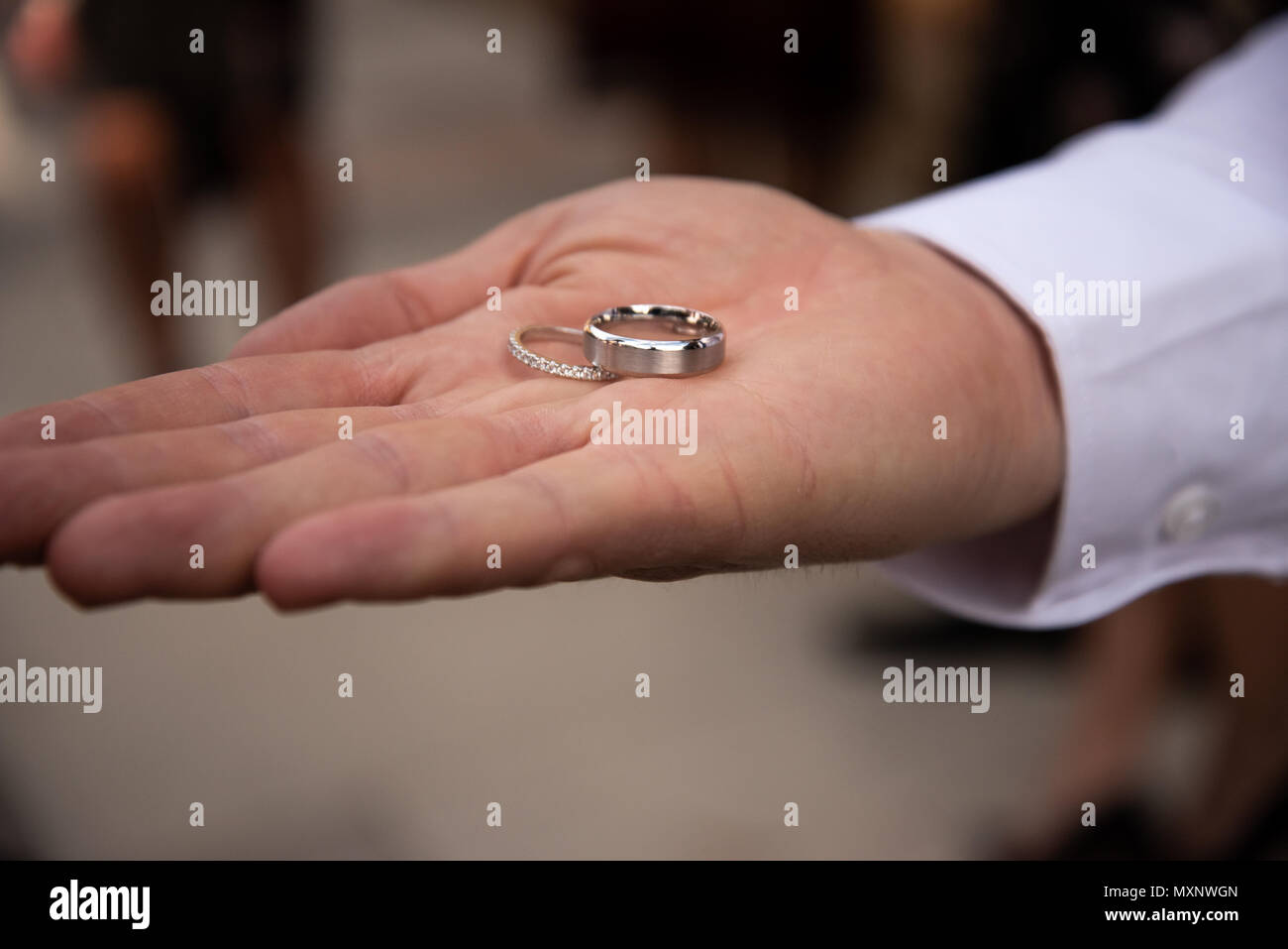 Wedding rings sitting on the palm of a mans hand Stock Photo
