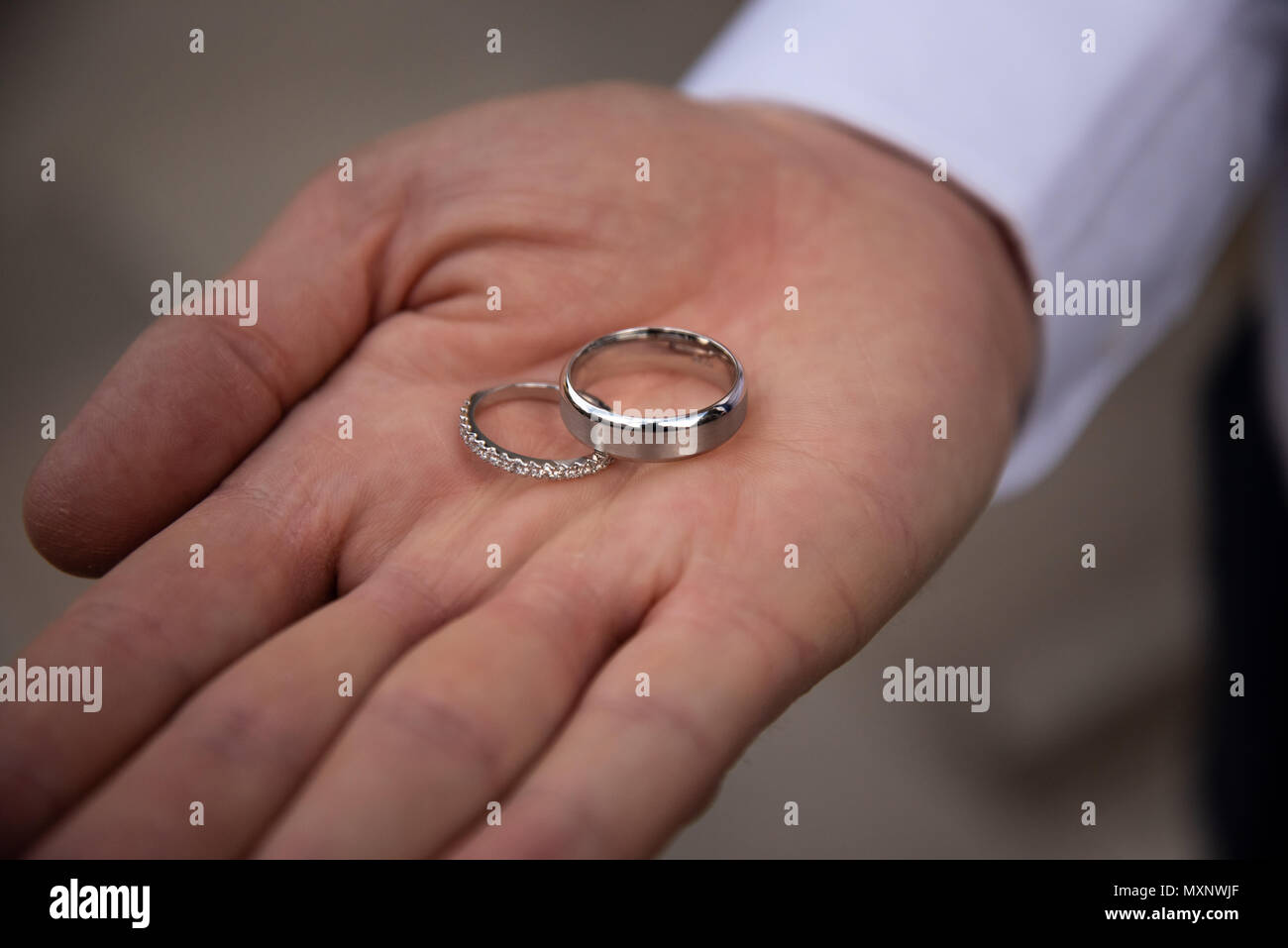 Wedding rings sitting on the palm of a mans hand Stock Photo