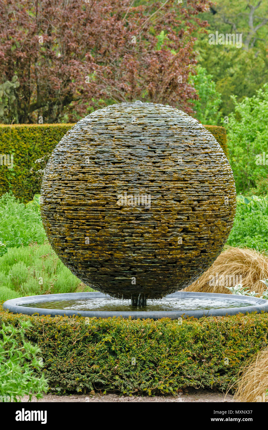 CAWDOR CASTLE NAIRN SCOTLAND GARDEN DETAIL OF GLOBE FOUNTAIN MADE FROM SLATES AND FLAT STONES IN THE WHITE GARDEN Stock Photo