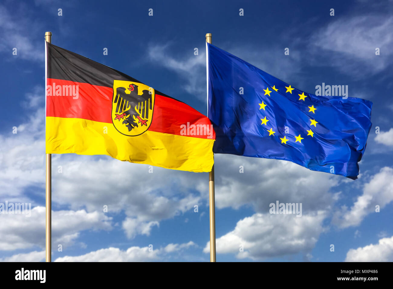 Flags of Germany (Federal Republic of Germany; in German: Bundesrepublik Deutschland) and the European Union (EU) waving in the wind on a bright sunny Stock Photo