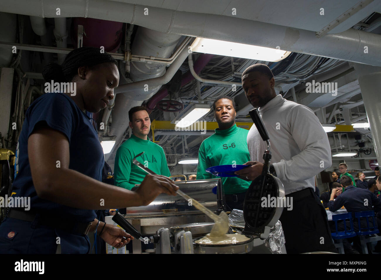 161127-N-KJ380-012  U.S. 5TH FLEET AREA OF OPERATIONS (Nov. 27, 2016) Petty Officer 3rd Class Detra Penn, from Saint Thomas, U.S. Virgin Islands, serves waffles to Sailors on the mess decks of the aircraft carrier USS Dwight D. Eisenhower (CVN 69) (Ike) during Sunday brunch. Ike and its carrier strike group are deployed in support of Operation Inherent Resolve, maritime security operations and theater security cooperation efforts in the U.S. 5th Fleet area of operations. (U.S. Navy photo by Seaman Neo Greene III) Stock Photo