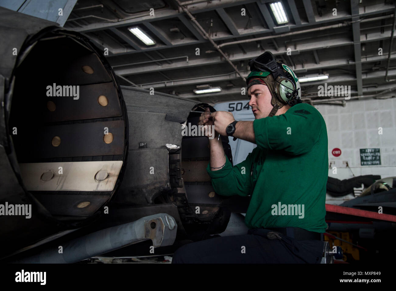 161125-N-QI061-032    ARABIAN GULF (Nov. 25, 2016) Petty Officer 3rd Class Jacob Wiggs, from Roswell, N.M. inspects the variable exhaust nozzle for a 200-hour flight engine inspection in the hangar bay of the aircraft carrier USS Dwight D. Eisenhower (CVN 69) (Ike). Ike and its Carrier Strike Group are deployed in support of Operation Inherent Resolve, maritime security operations and theater security cooperation efforts in the U.S. 5th Fleet area of operations. (U.S. Navy photo by Petty Officer 3rd Class Nathan T. Beard) Stock Photo
