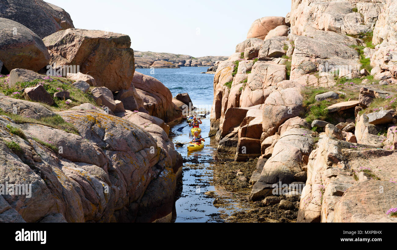 Smogen, Sweden - May 19, 2018: Travel documentary of everyday life and place. Three canoeists forced to back out from a blocked and narrow canal in ro Stock Photo