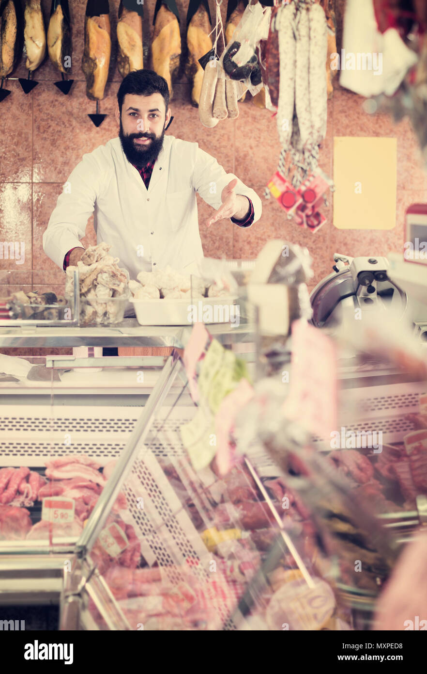 Happy man seller showing meat in butcher’s shop Stock Photo - Alamy