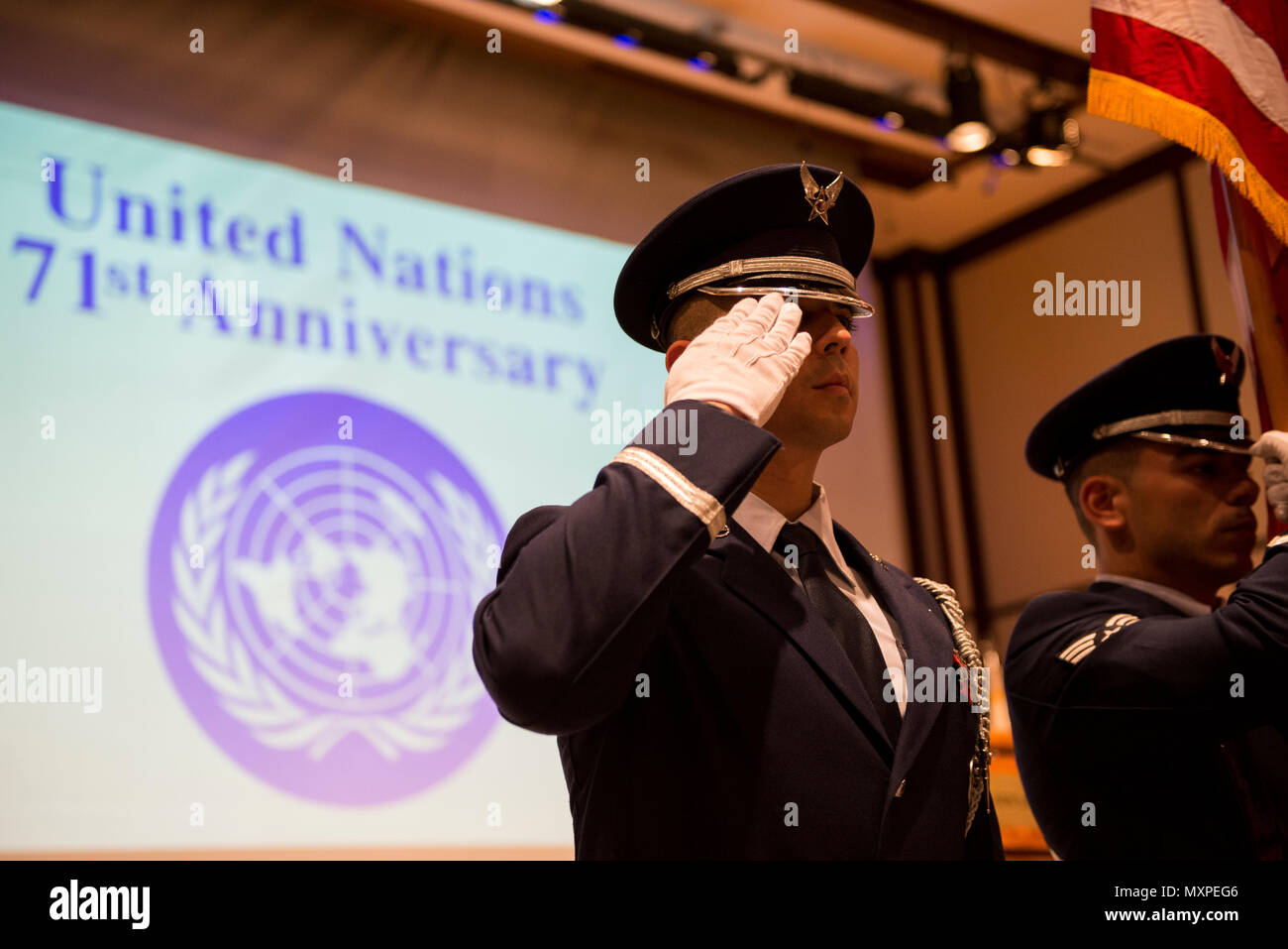 A Yokota Air Base Honor Guard member salutes during the presentation of the colors ceremony during the United Nations Day 71st Anniversary Celebration in Tokyo, Japan, Nov. 21, 2016. United Nations Day commemorates the anniversary of the United Nations Charter in 1945 and has been celebrated as U.N. Day since 1948. (U.S. Air Force photo by Airman 1st Class Donald Hudson/Released) Stock Photo