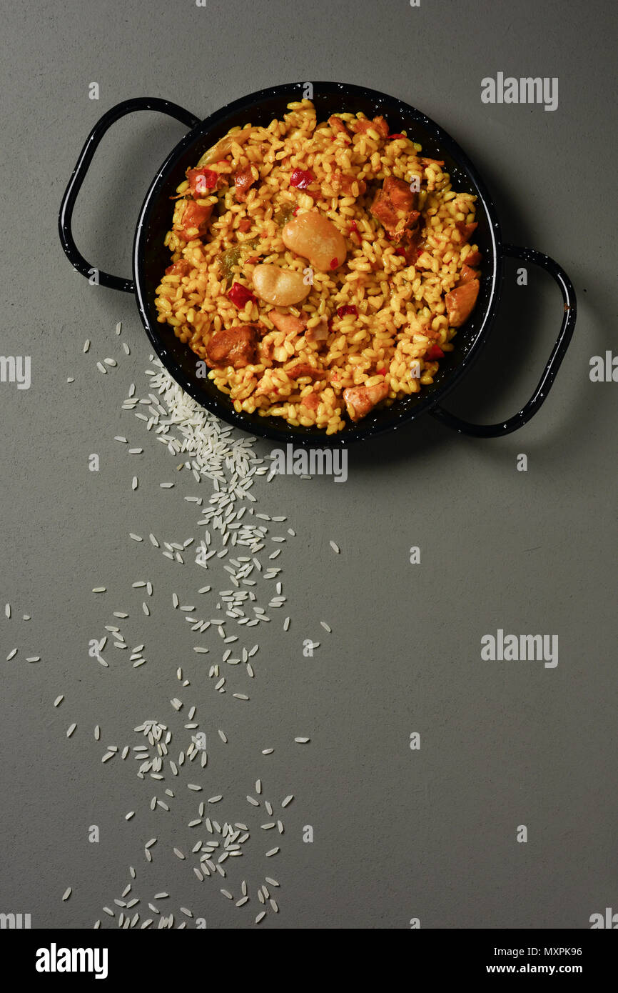 high angle view of a typical spanish paella valenciana in a typical paella pan, on a gray rustic table Stock Photo