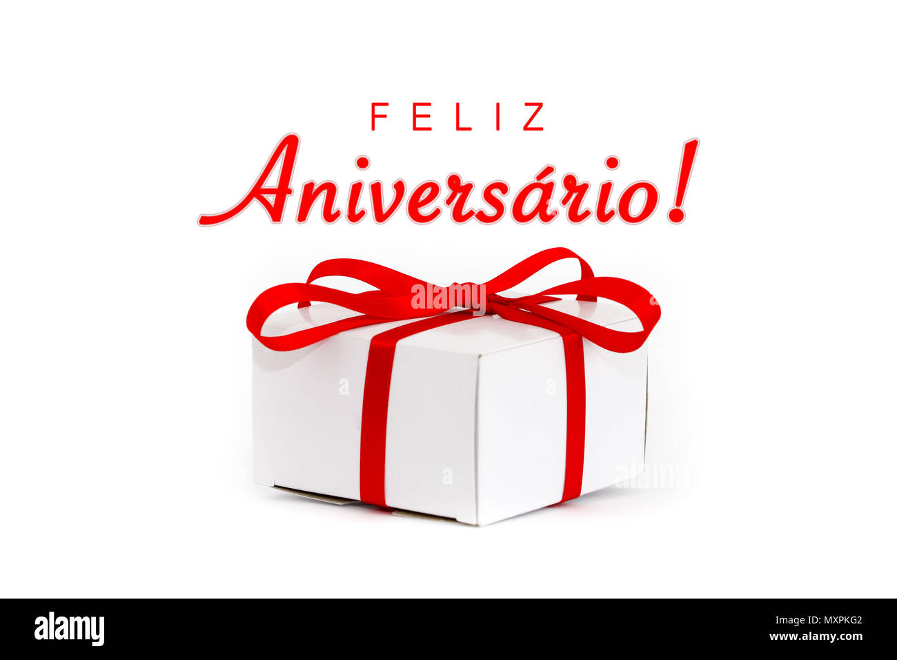 Feliz Aniversario! (in Portuguese language: Happy Birthday!) text message and white cardboard gift box with decorative red ribbon and tied bow isolate Stock Photo