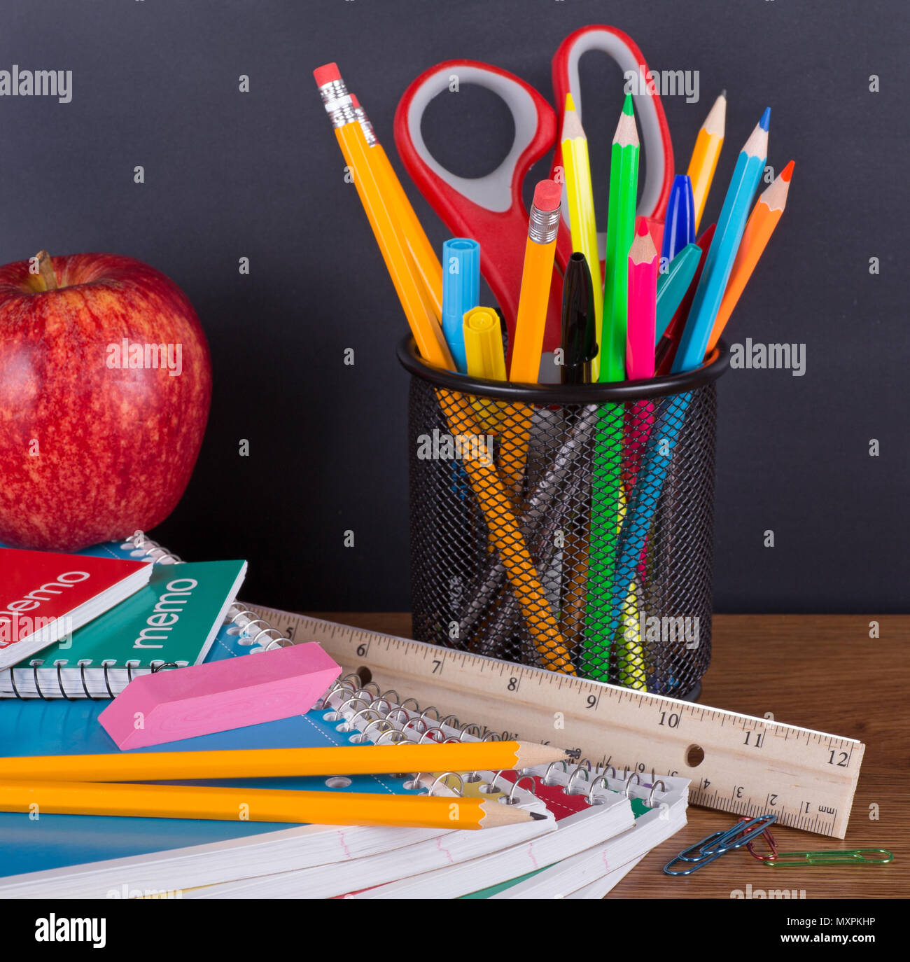 Closeup of an assortment of school supplies on a chalkboard background Stock Photo