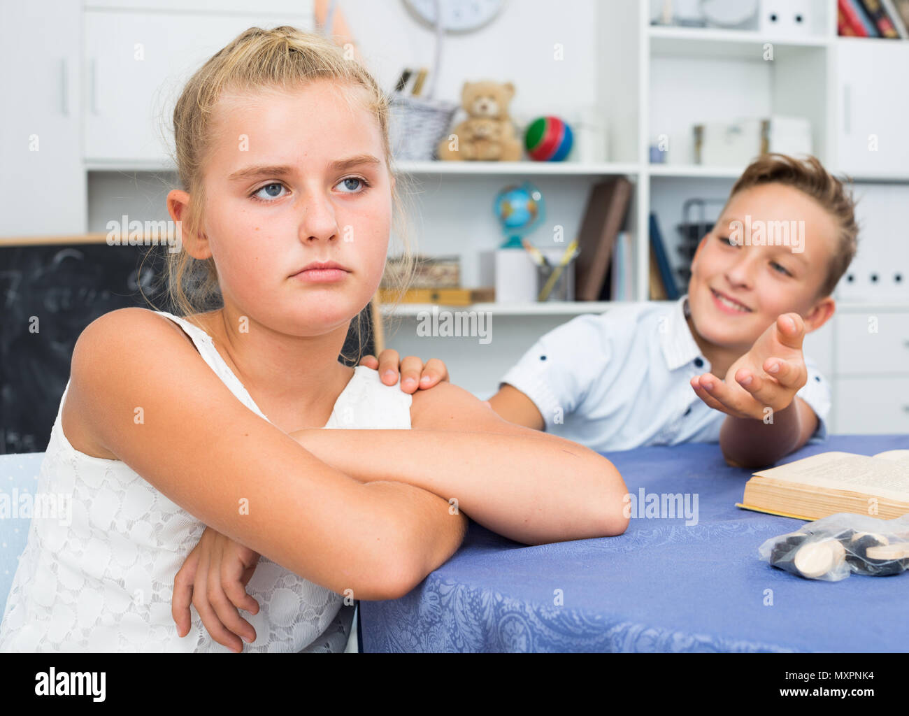 Boy is excusing for the offendedly girl at home. Stock Photo