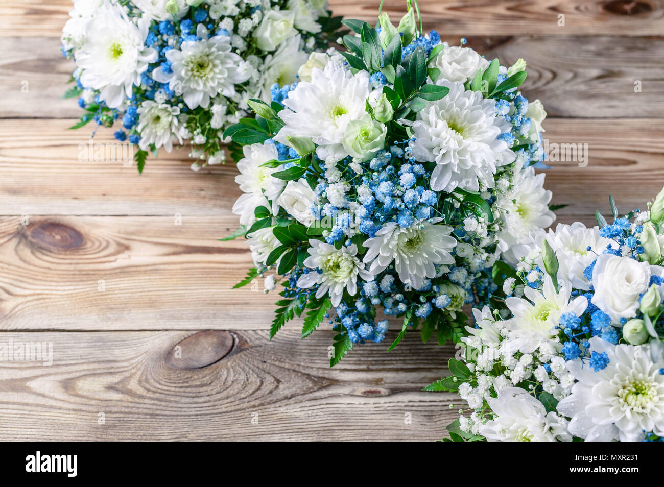 Wedding bouquets bridesmaids in white and blue chrysanthemums on a wooden background. Top view Stock Photo