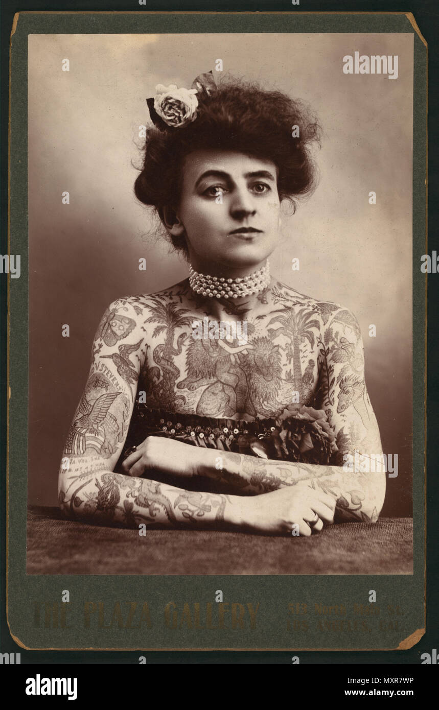 Photograph shows a half-length portrait of a woman with tattoos or body paint covering her arms and chest, Los Angeles, CA, 1907. Stock Photo