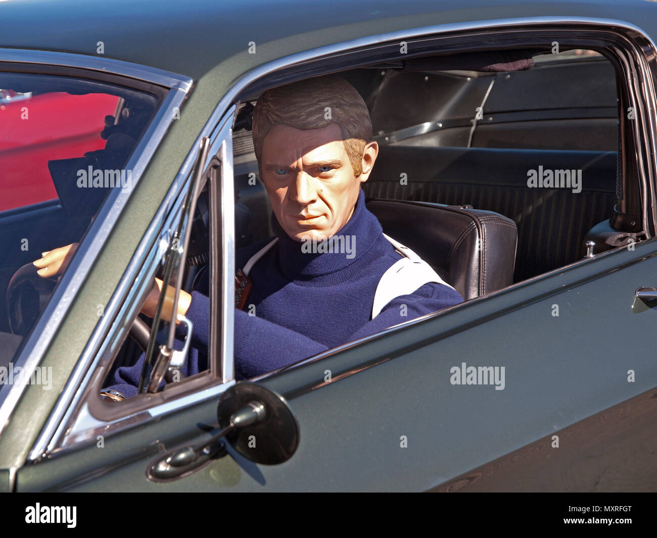 At a classic car rally in Brighton sits a model of the actor Steve McQueen as seen in the film Bullitt Stock Photo