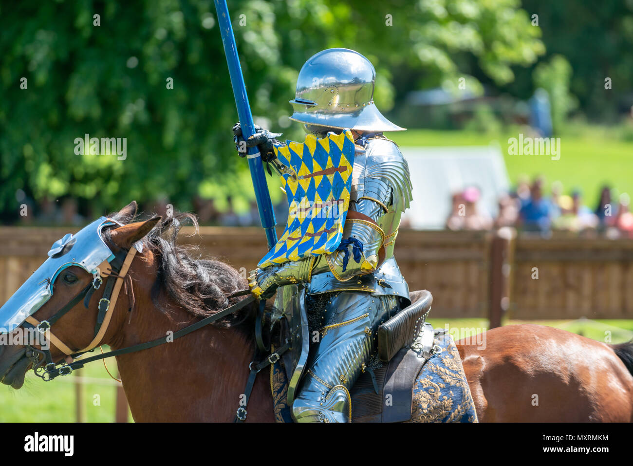 A knight in armour riding a horse during a jousting competition at the
