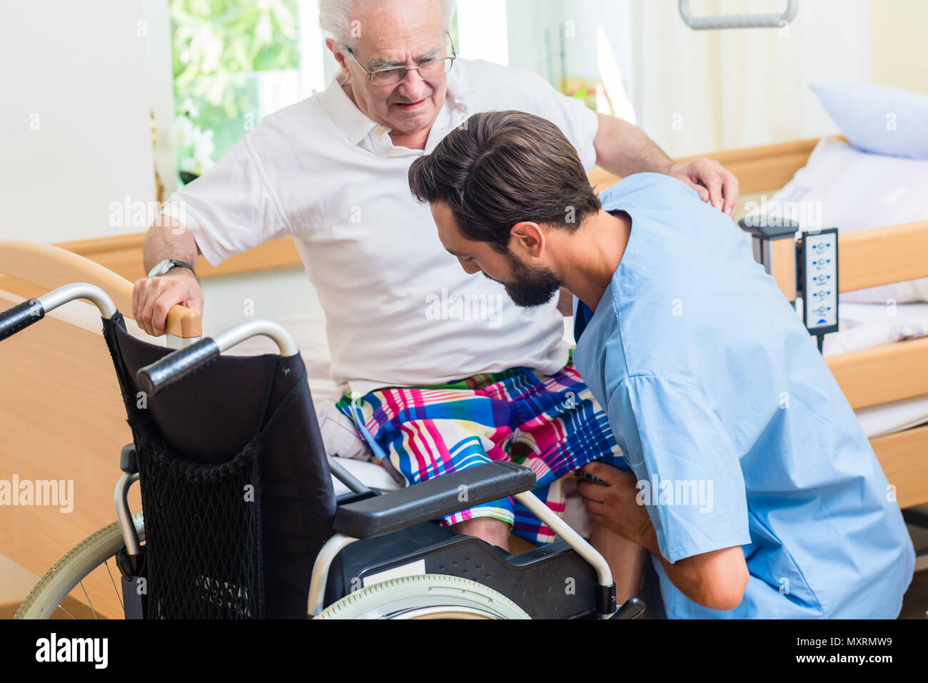 Nurse moving elderly hospital bed hires stock photography and images